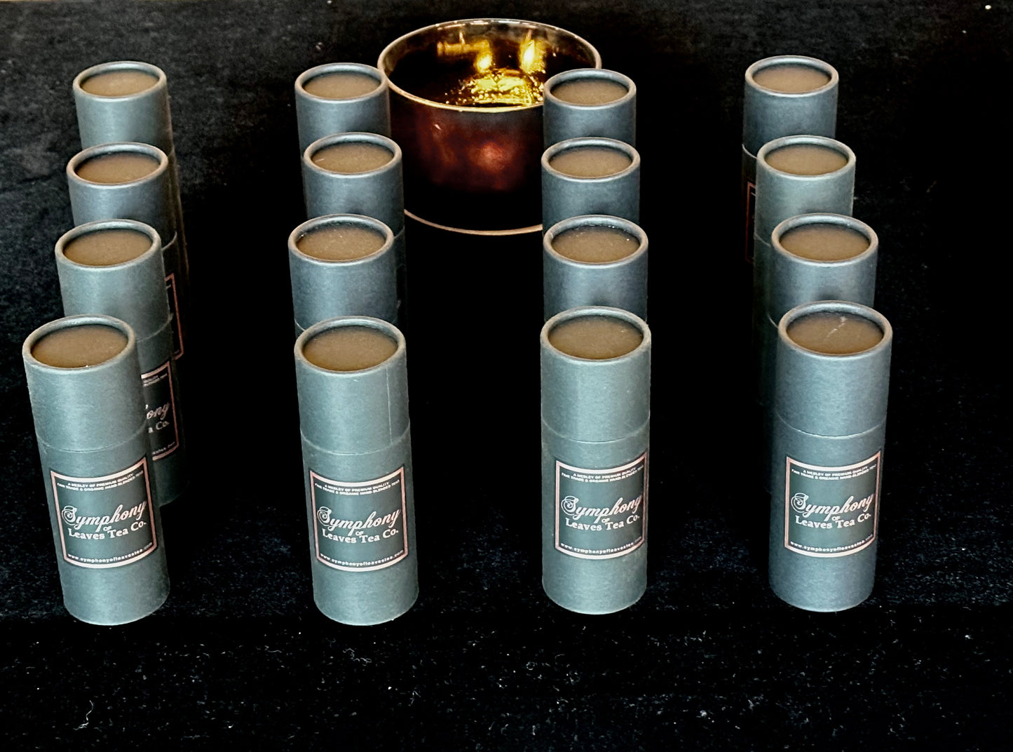 Symphony of Leaves branded tea canisters with candle in the background
