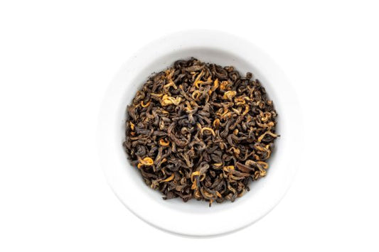 Dry Himalayan Golden black tea leaves in a white bowl on a white background