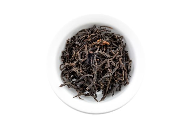 Chinese Dry black tea leaves in a white bowl on a white background