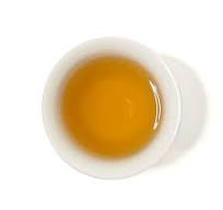Tea cup with brewed Vietnamese oolong tea on a white background