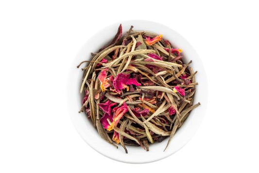 Bai Long Xu White Tea, blended with dehydrated roses and lavender, in a white bowl.
