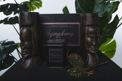 Green Tea blended with figs, lemongrass and safflower. 'Symphony of Leaves Tea Co.' packaging with wooden sculptures and leaves in the background