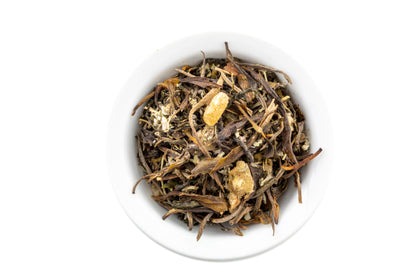 Green Tea leaves in a white bowl on a white background