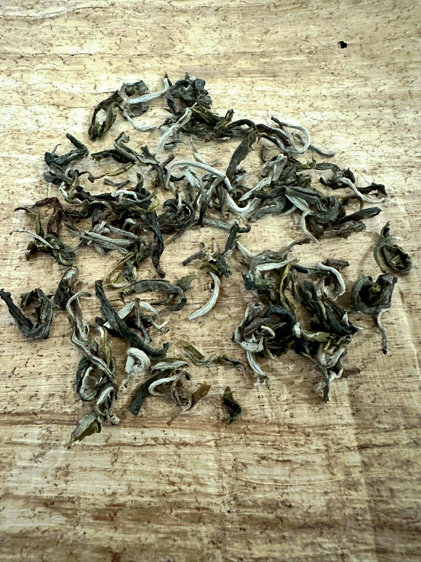 Vietnamese loose leaf green tea on a cream colored mat.