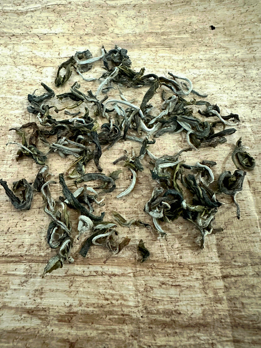 Vietnamese loose leaf green tea on a cream colored mat.