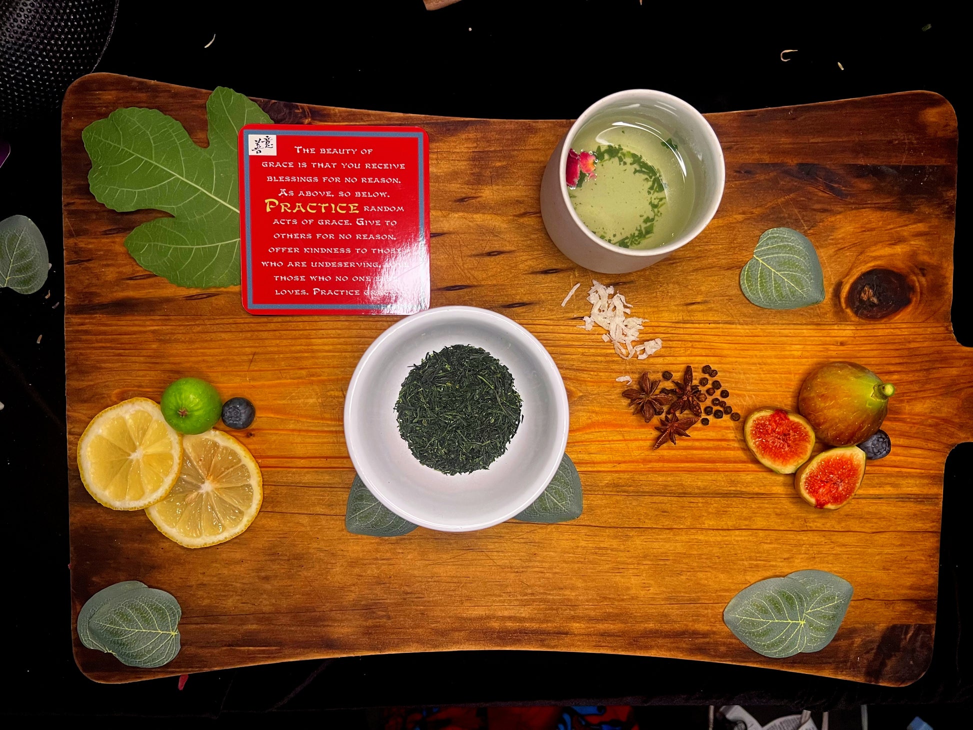 Reserve Gyokuro displayed on a wood block surrounded dehydrated figs and lemons.