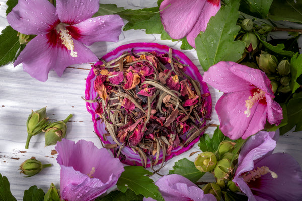 Full bodied white teas blended with dehydrated pink roses and lavender displayed on a whitewashed board.