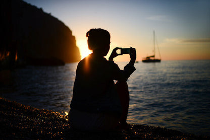 Person enjoying tea dat the sea  during sunset