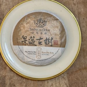 Raw Pu-Erh tea cake on wooden background