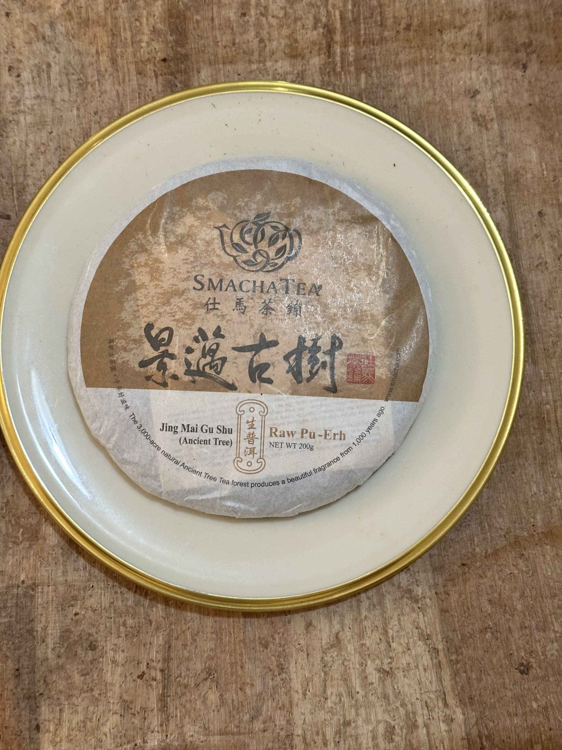 Raw Pu-Erh tea cake on wooden background