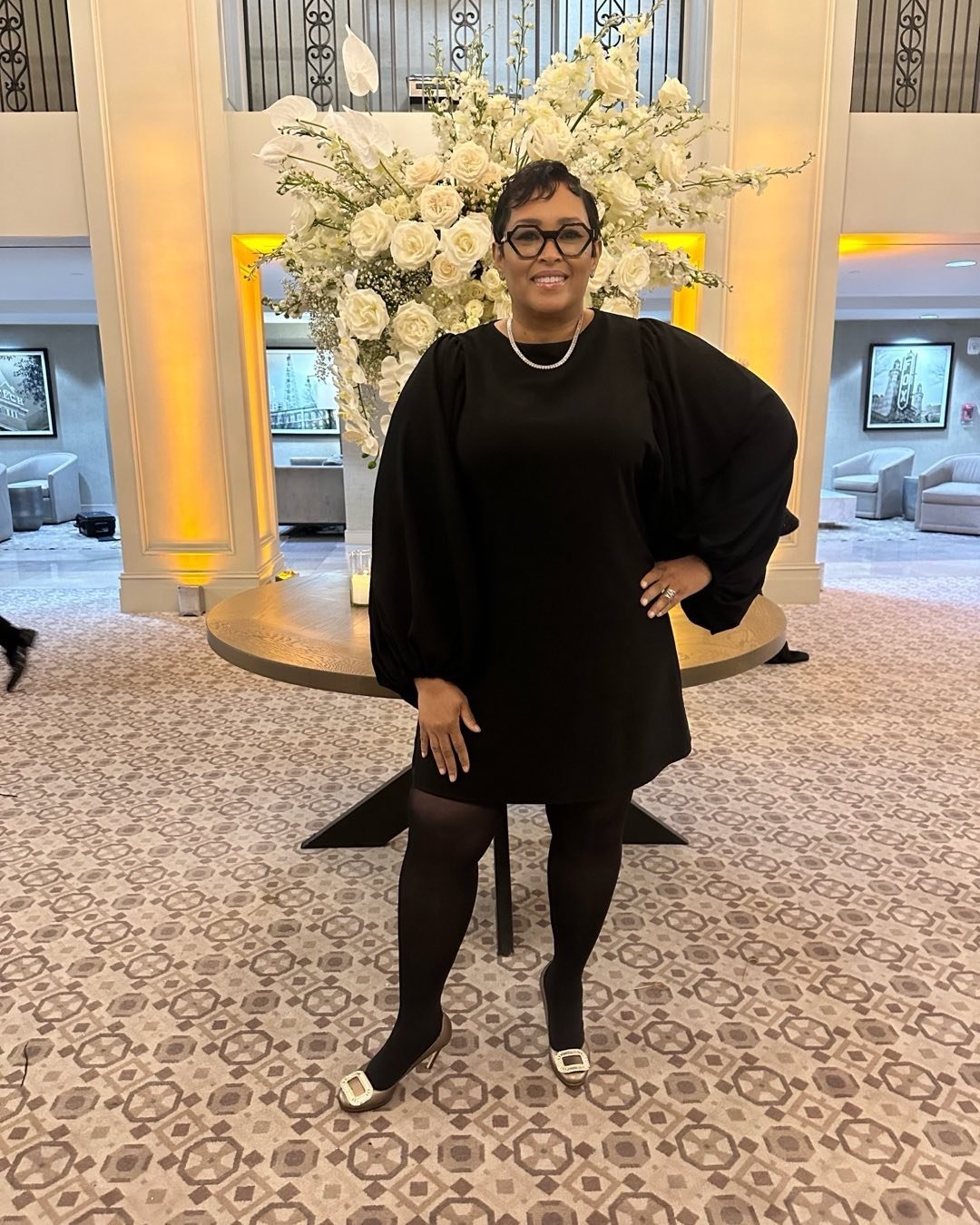 Woman in elegant black dress smiling indoors