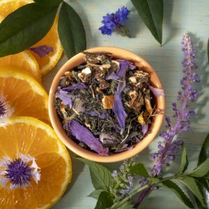 Herbal tea blend with orange slices and flowers.