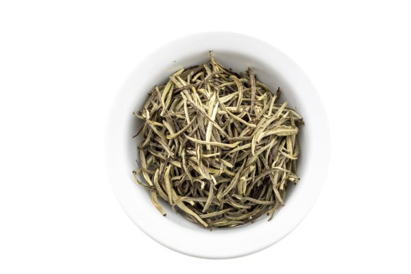 White tea leaves in a ceramic bowl.