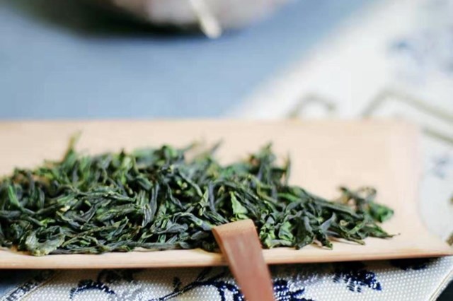 Dried green tea leaves on wooden plate