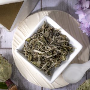 White tea leaves in a ceramic bowl.