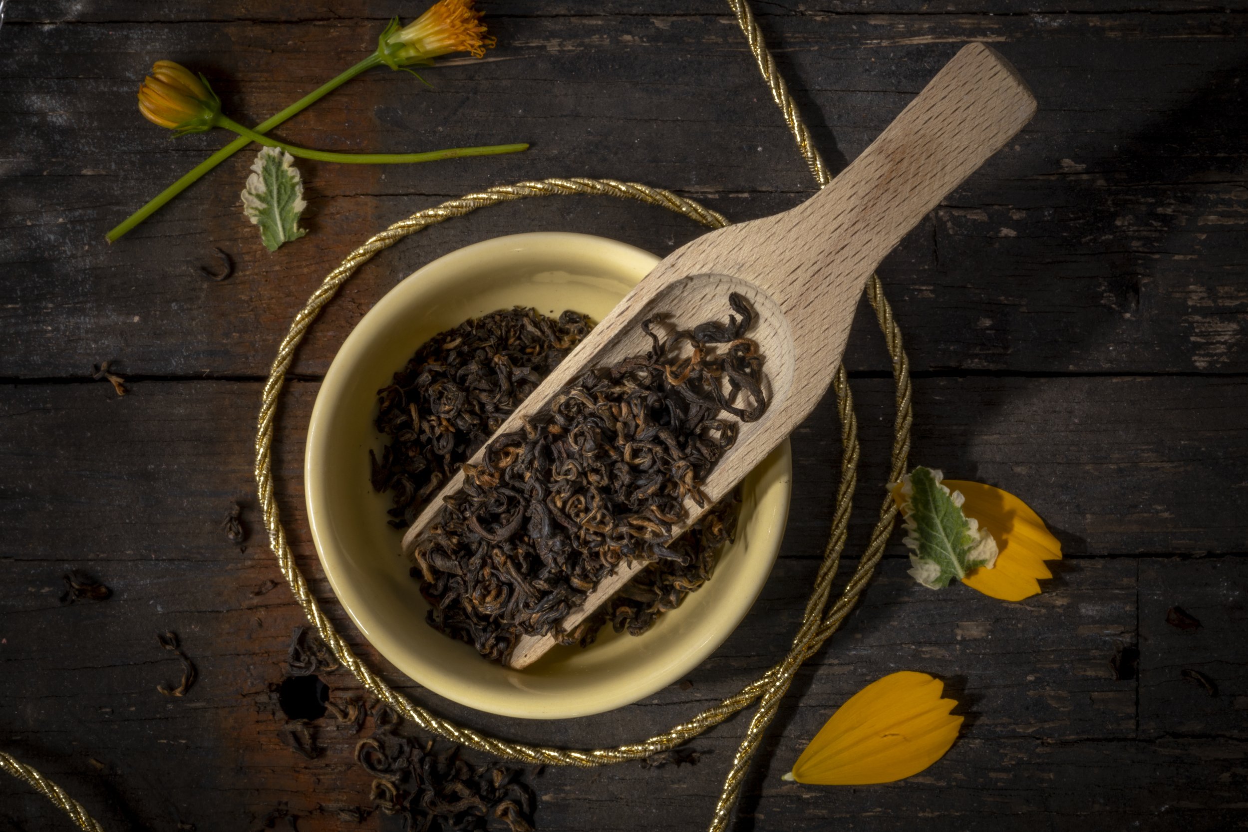 Aromatic black tea leaves in wooden scoop