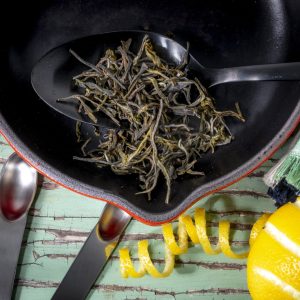 Dried tea leaves in cast iron skillet cooking