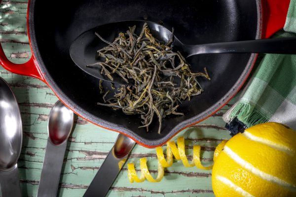 Dried tea leaves in cast iron skillet cooking