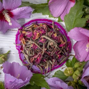 Tea leaves surrounded by vibrant pink flowers