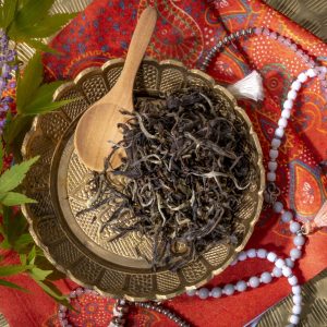 Loose leaf tea on decorative plate with beads