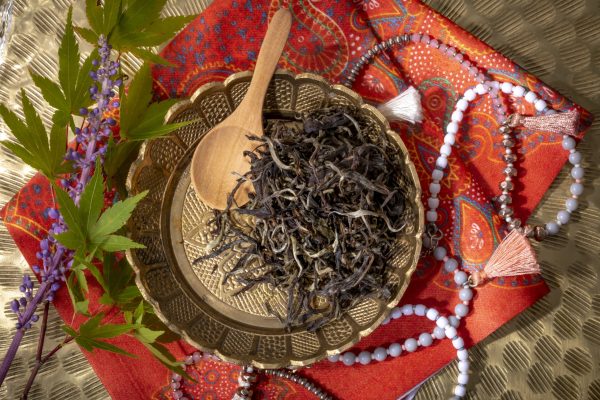 Loose leaf tea on decorative plate with beads