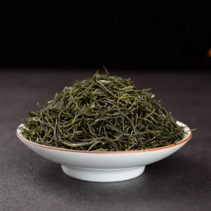 Aromatic green tea leaves in white bowl