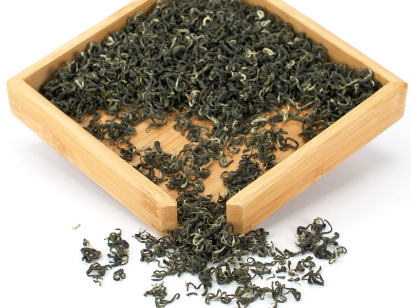 Loose black tea leaves in wooden tray