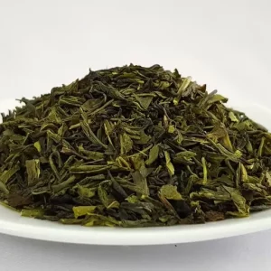 Dried green tea leaves on white plate